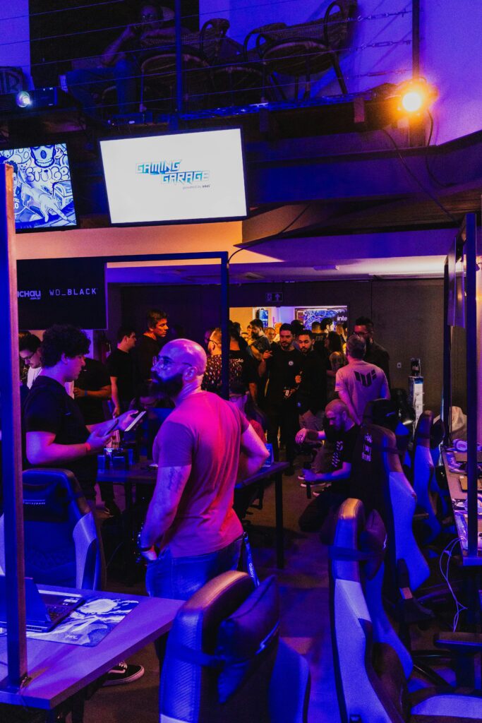 A bustling gaming expo showcasing technology with people engaged at gaming stations.