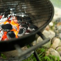 Charcoal glowing intensely in a barbecue grill, perfect for grilling and outdoor cooking on a summer day.